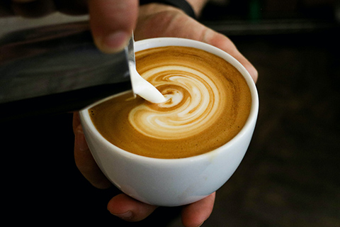 barista pouring a cafe latte