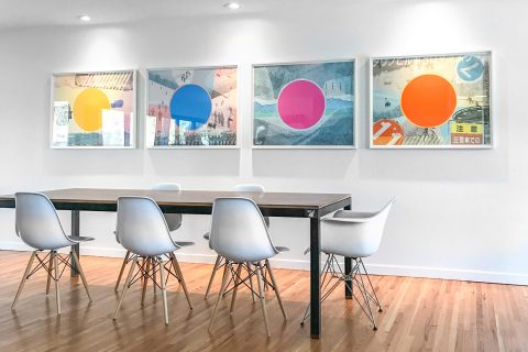 four artworks by jamie kripke hanging in a modern dining room