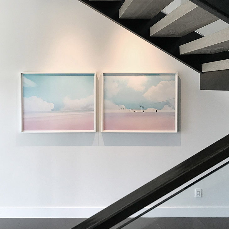 two artworks by jamie kripke hanging near a modern staircase